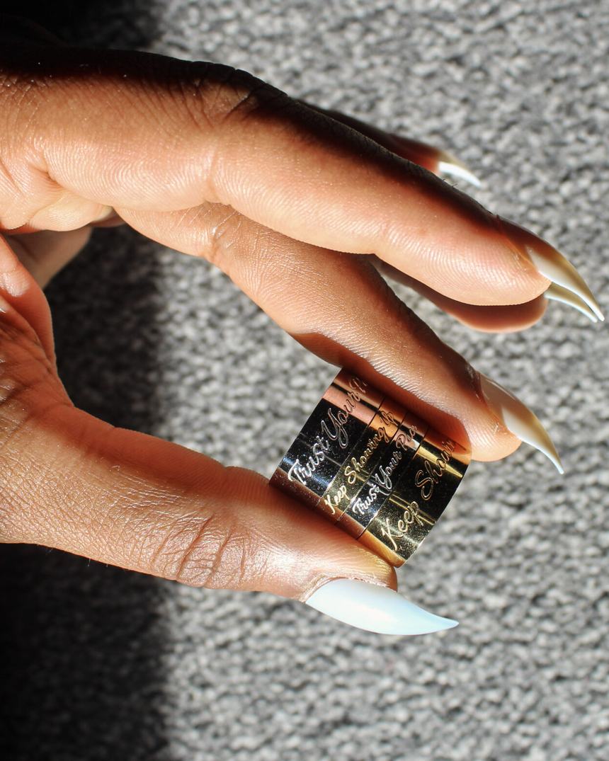 Three engraved bands held between finger and thumb.