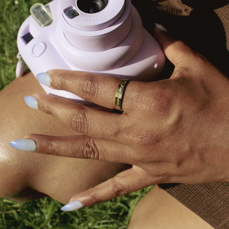 Trust Your Pace ring in gold, worn outdoors.