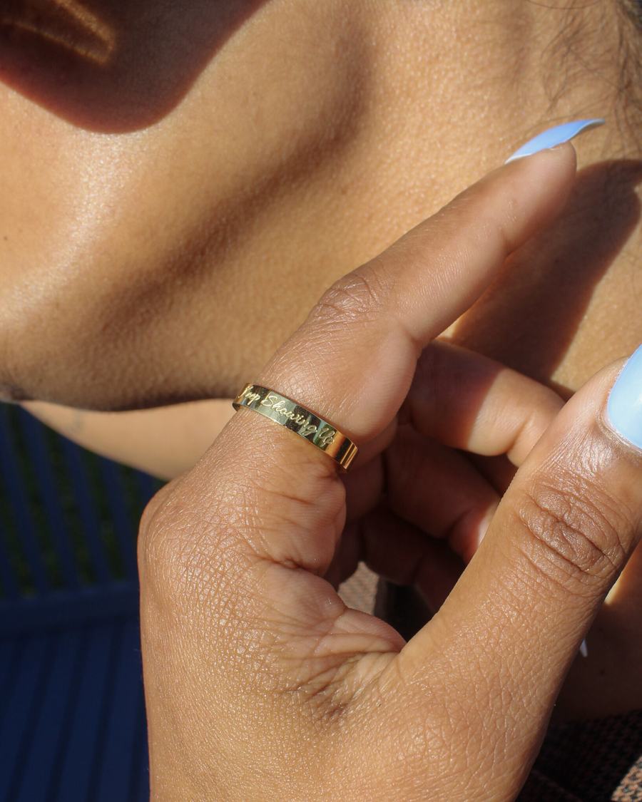 The band worn on the ring finger, hand raised to the ear.